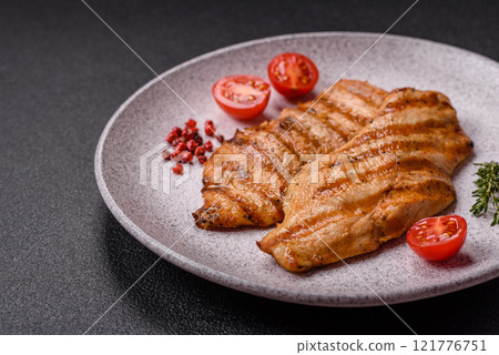 Juicy chicken fillet baked on the grill with salt, spices and herbs 121776751