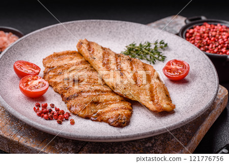 Juicy chicken fillet baked on the grill with salt, spices and herbs Juicy chicken fillet baked on the grill with salt, spices and herbs 121776756