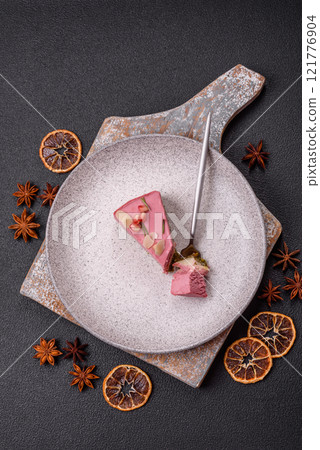Piece of sweet cheesecake with pink cream cheese of raspberry or strawberry flavor Piece of sweet cheesecake with pink cream cheese of raspberry or strawberry flavor 121776904