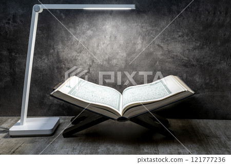 Desk lamp with Quran on Quran matt on a black background 121777236