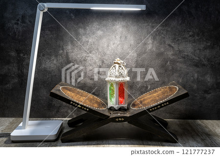 Desk lamp with Arabic lantern on Quran matt on a black background 121777237