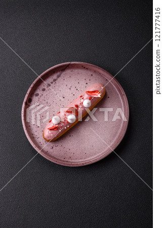 Sweet eclair or profiterole with strawberry custard 121777416