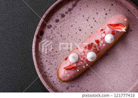 Sweet eclair or profiterole with strawberry custard 121777418