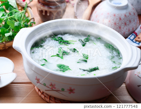 Eating Nanakusa-gayu (rice porridge with seven herbs) to pray for good health Eating Nanakusa-gayu (rice porridge with seven herbs) to pray for good health 121777548