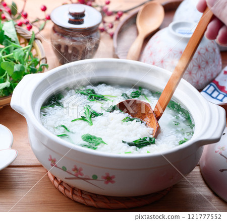 Eating Nanakusa-gayu (rice porridge with seven herbs) to pray for good health Eating Nanakusa-gayu (rice porridge with seven herbs) to pray for good health 121777552