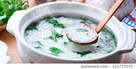 Eating Nanakusa-gayu (rice porridge with seven herbs) to pray for good health Eating Nanakusa-gayu (rice porridge with seven herbs) to pray for good health 121777555