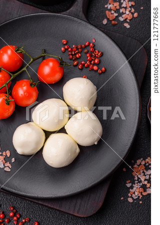 Delicious fresh mozzarella cheese with tomatoes, salt and spices Delicious fresh mozzarella cheese with tomatoes, salt and spices 121777668