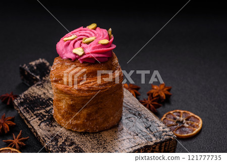 Sweet craffin or panettone garnished with raspberry and pistachio flavored cream Sweet craffin or panettone garnished with raspberry and pistachio flavored cream 121777735