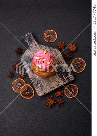 Sweet craffin or panettone garnished with raspberry and pistachio flavored cream 121777740