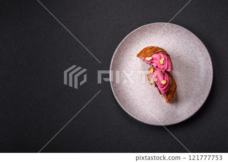 Sweet craffin or panettone garnished with raspberry and pistachio flavored cream Sweet craffin or panettone garnished with raspberry and pistachio flavored cream 121777753