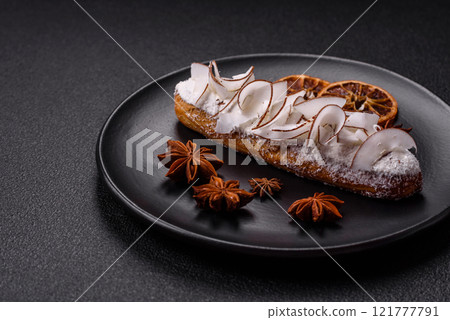 Sweet eclair with custard decorated with coconut slices Sweet eclair with custard decorated with coconut slices 121777791