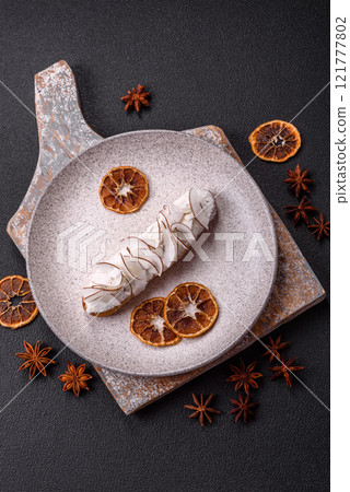 Sweet eclair with custard decorated with coconut slices 121777802
