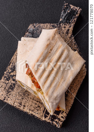 Roll with pita, meat, tomatoes, cheese, sauce, salt and spices Roll with pita, meat, tomatoes, cheese, sauce, salt and spices 121778070