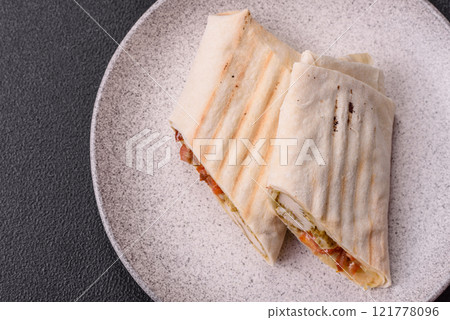 Roll with pita, meat, tomatoes, cheese, sauce, salt and spices Roll with pita, meat, tomatoes, cheese, sauce, salt and spices 121778096