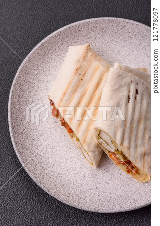 Roll with pita, meat, tomatoes, cheese, sauce, salt and spices Roll with pita, meat, tomatoes, cheese, sauce, salt and spices 121778097