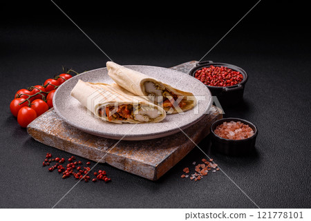 Roll with pita, meat, tomatoes, cheese, sauce, salt and spices Roll with pita, meat, tomatoes, cheese, sauce, salt and spices 121778101