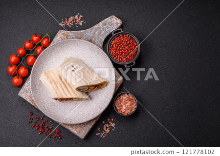 Roll with pita, meat, tomatoes, cheese, sauce, salt and spices Roll with pita, meat, tomatoes, cheese, sauce, salt and spices 121778102
