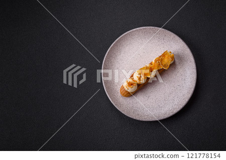 Sweet dessert eclairs or profiteroles with chocolate filling 121778154