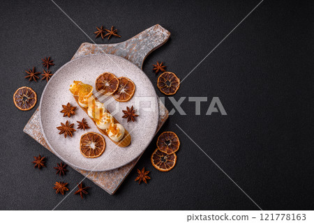 Sweet dessert eclairs or profiteroles with chocolate filling 121778163