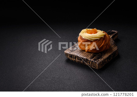 Sweet dessert danish with raisins, cream and pear filling 121778201