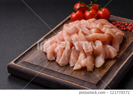 Raw chicken fillet cut into strips with spices and herbs Raw chicken fillet cut into strips with spices and herbs 121778572