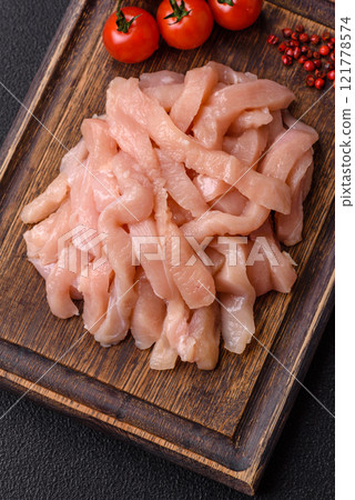 Raw chicken fillet cut into strips with spices and herbs Raw chicken fillet cut into strips with spices and herbs 121778574