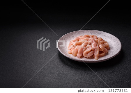Raw chicken fillet cut into strips with spices and herbs Raw chicken fillet cut into strips with spices and herbs 121778581