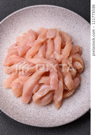 Raw chicken fillet cut into strips with spices and herbs 121778586
