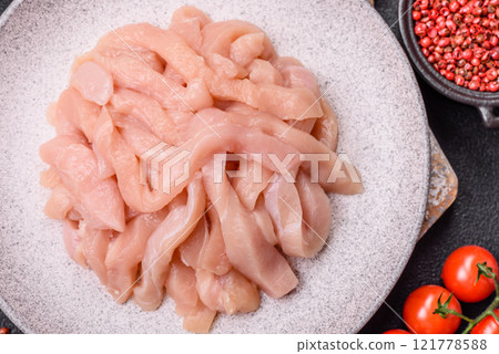 Raw chicken fillet cut into strips with spices and herbs Raw chicken fillet cut into strips with spices and herbs 121778588