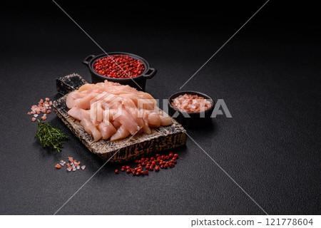 Raw chicken fillet cut into strips with spices and herbs Raw chicken fillet cut into strips with spices and herbs 121778604