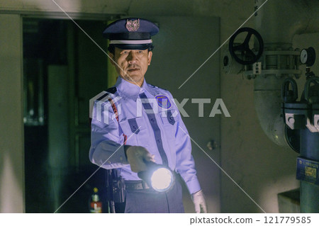 夜間拿著手電筒守衛大樓的男性保全攝影提供:東京電子學院登波學園教育法人。 夜間拿著手電筒守衛大樓的男性保全攝影提供:東京電子學院登波學園教育法人。 121779585