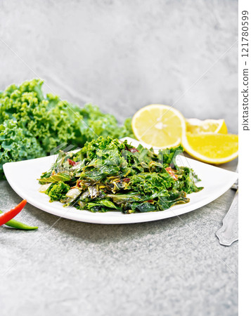Kale cabbage with orange and pepper in plate on granite table Kale cabbage with orange and pepper in plate on granite table 121780599