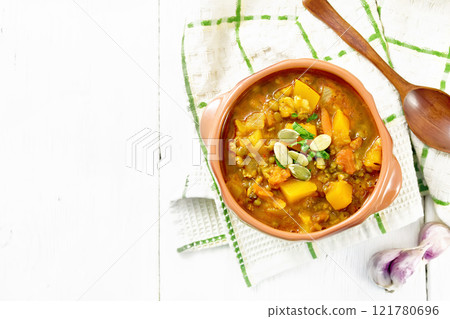 Soup-curry with pumpkin and lentils in bowl on white board top 121780696