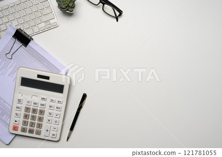 Top view of a tidy workspace with calculator, keyboard, glasses and a stack of documents Top view of a tidy workspace with calculator, keyboard, glasses and a stack of documents 121781055