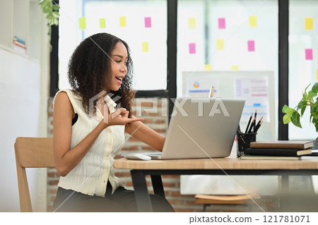 Businesswoman having a video conference on laptop at her office 121781071