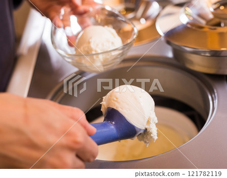 Scoop of creamy ice cream in spoon from the refrigerator container Scoop of creamy ice cream in spoon from the refrigerator container 121782119
