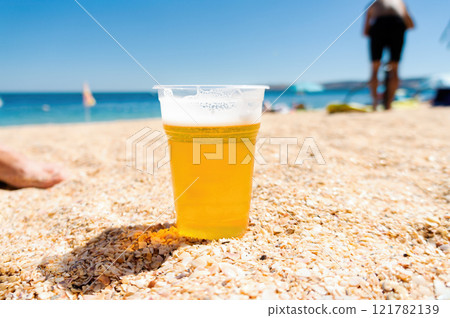 Refreshing Beer in a Transparent Cup on a Sunny Beach Vacation Refreshing Beer in a Transparent Cup on a Sunny Beach Vacation 121782139
