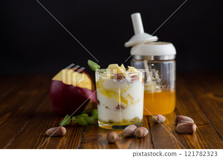 sweet homemade yogurt in a glass with apples, nuts and honey sweet homemade yogurt in a glass with apples, nuts and honey 121782323