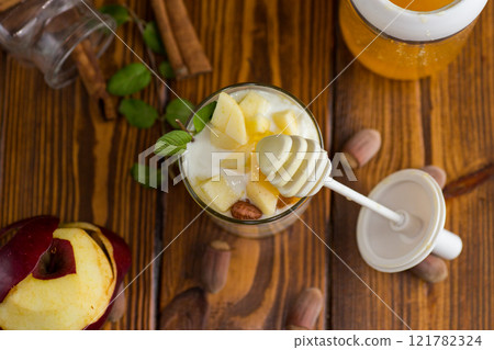 sweet homemade yogurt in a glass with apples, nuts and honey 121782324