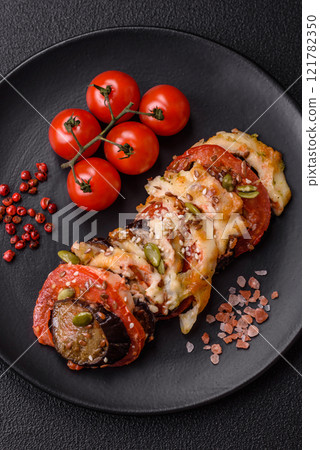 Rings of eggplant, tomato and zucchini with pieces of chicken and garlic 121782350