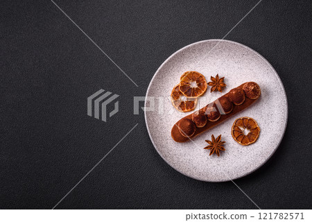 Sweet eclair with chocolate custard sprinkled with cocoa powder 121782571