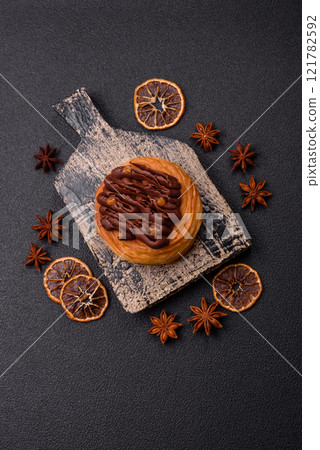 Sweet dessert danish covered with chocolate cream, with cream filling 121782592