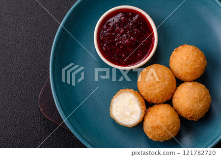 French fries balls with breaded brie or camembert cheese with sweet berry sauce French fries balls with breaded brie or camembert cheese with sweet berry sauce 121782720
