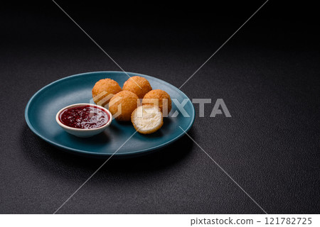 French fries balls with breaded brie or camembert cheese with sweet berry sauce 121782725