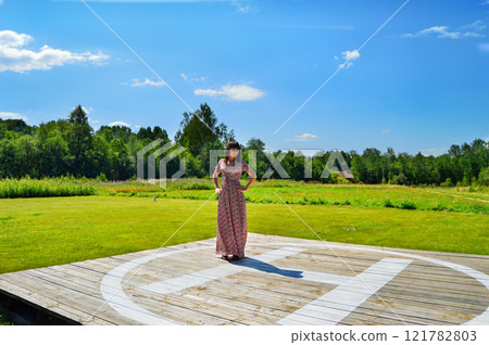 Stylish Young Woman Posing on a Helipad with a Stunning Natural Background Stylish Young Woman Posing on a Helipad with a Stunning Natural Background 121782803