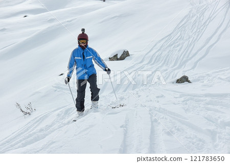 Skiing in the winter snowy slopes, woman skiing off track Skiing in the winter snowy slopes, woman skiing off track 121783650