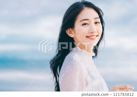 Beauty image of a young woman with blue sky background 121783812