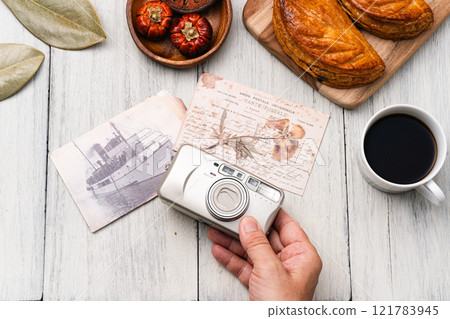 Camera and postcards on the table 121783945