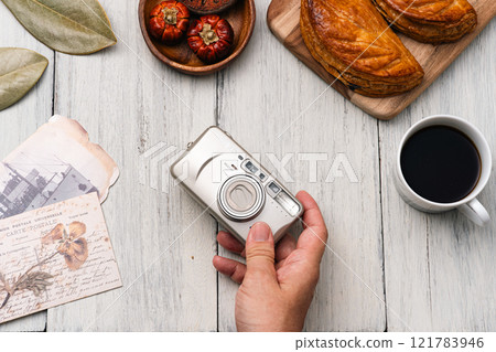 Camera and postcards on the table 121783946