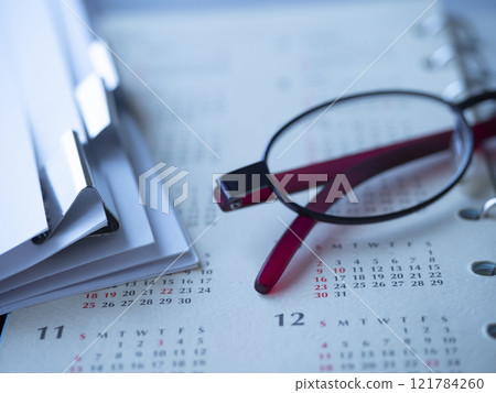 Calendar, documents and glasses on the table 121784260